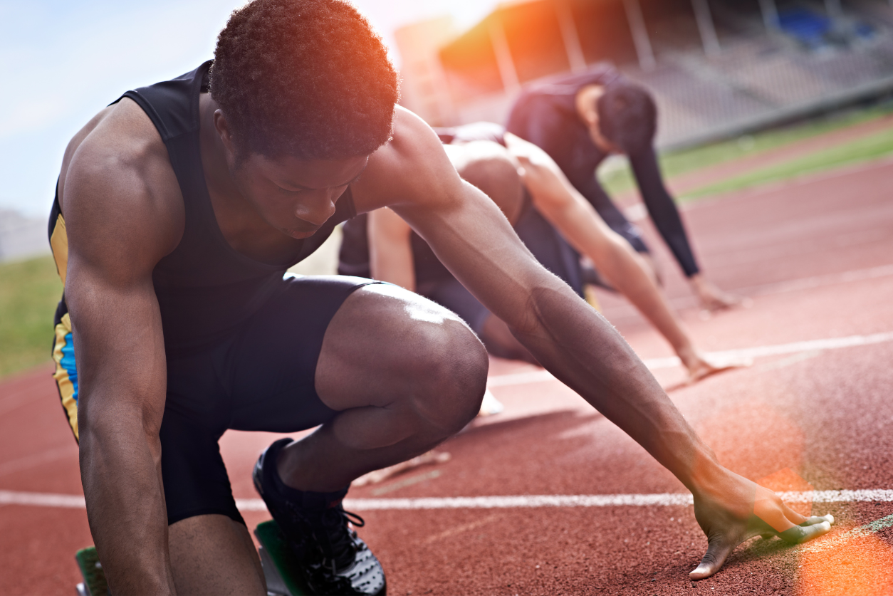 A track athlete crouches in the starting position waiting for a race to start.