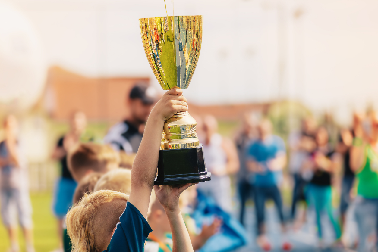 Blurry image of a child holding up a trophy