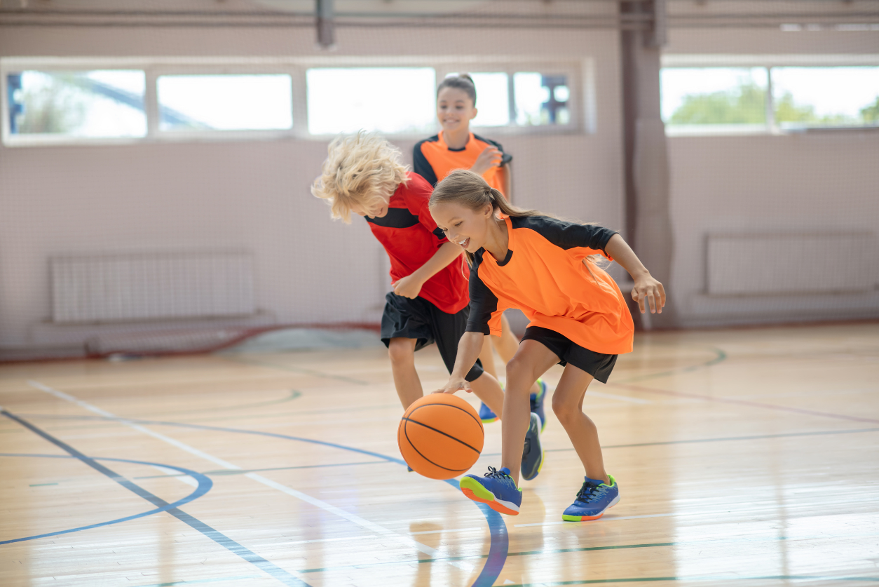 Kids playing basketball in an indoor court
