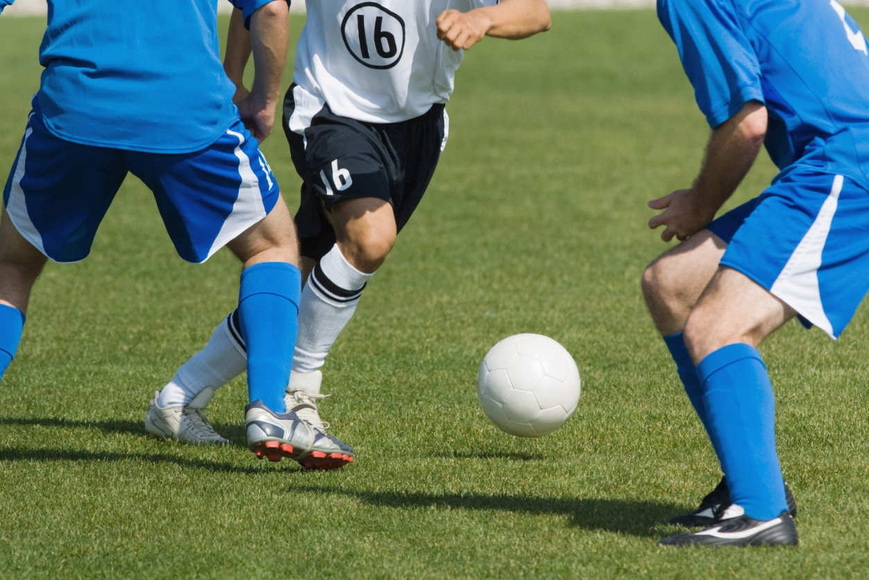 Two teams going for a soccer ball