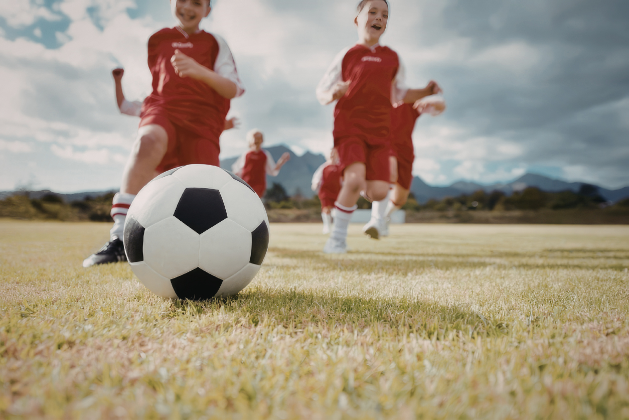 Kids running after a soccer ball