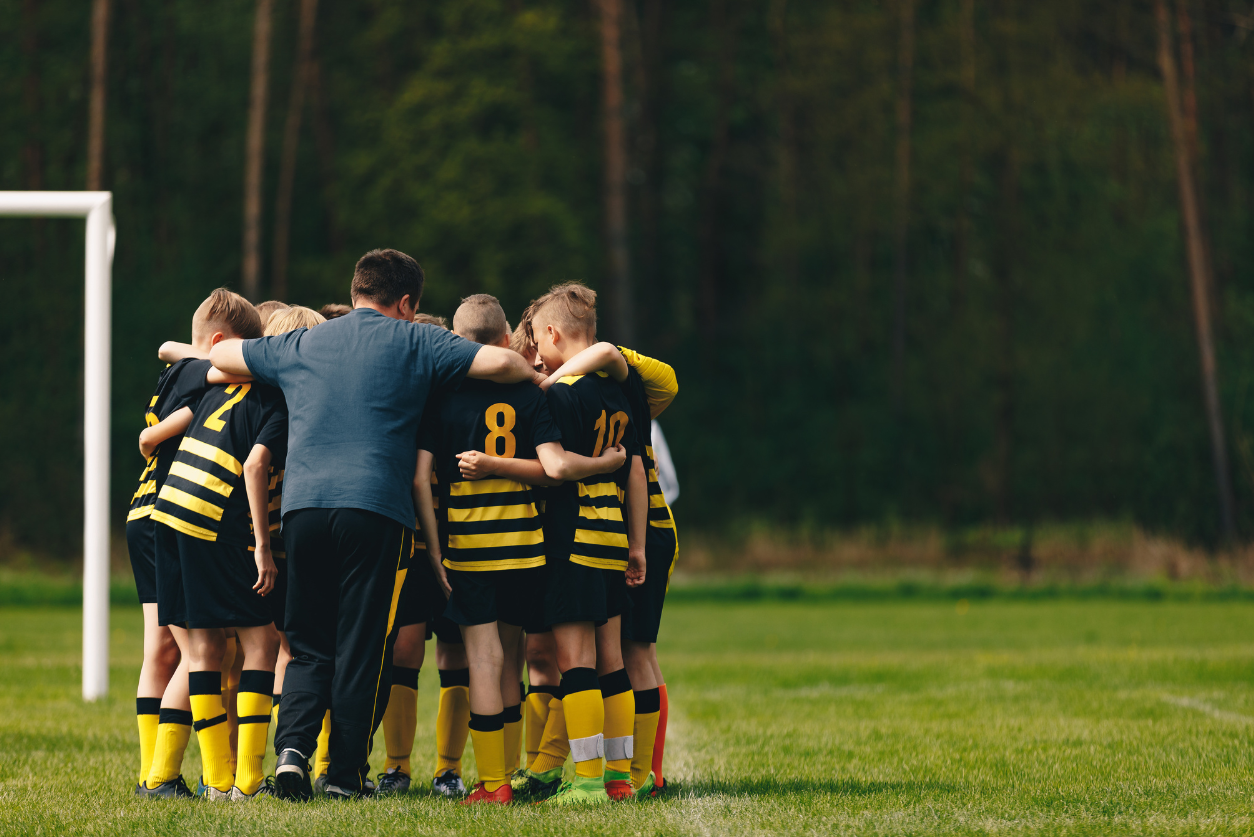 Soccer team huddles up with the coach